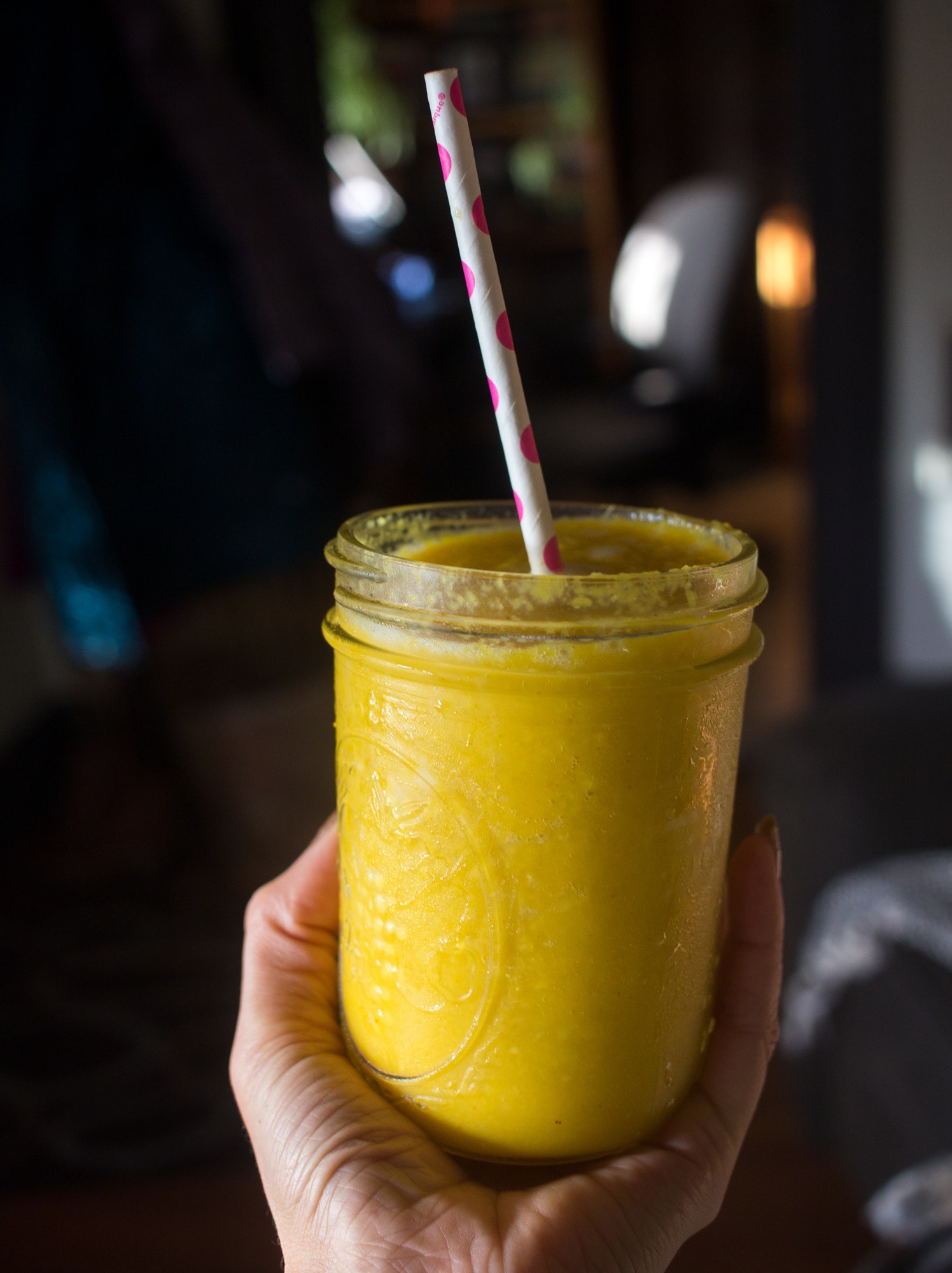 Mango turmeric smoothie with paper straw